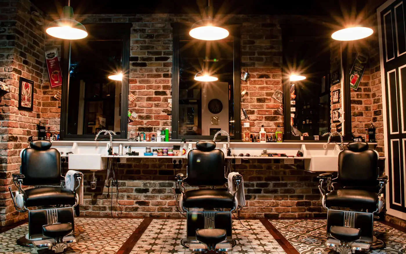 Sillón de barbería junto a un muro de ladrillo